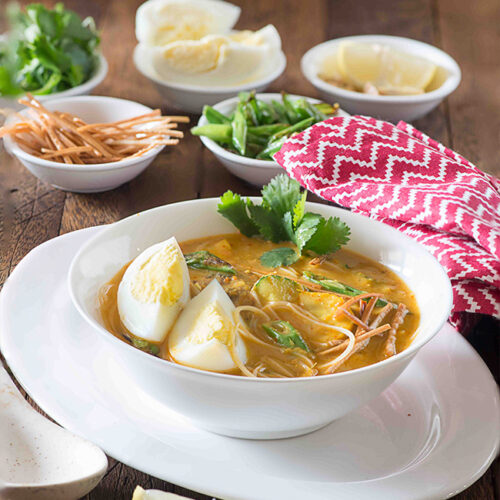 Khaw Suey is soup meal bowl inspired from Burmese noodle dish Ohn Khauk swe. The Burmese Khaw Suey Soup is vibrant in flavours, has lots of veggies and noodles cooked in coconut curry based soup.