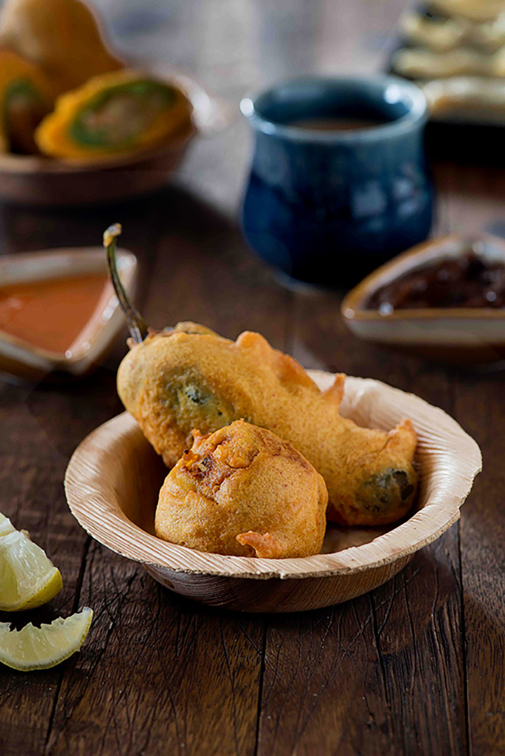 Rajasthani Mirchi Vada or popularly known as Jodhpuri Mirchi vada is famous street food from Rajasthan. Big Green chilli peppers stuffed with spicy aloo masala and batter fried are served with spicy green chutney and sweet tamarind chutney.