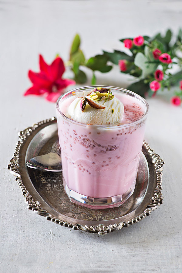 Rose falooda a cooling summer dessert which is rich and delicious. It’s made with milk rose syrup chia seeds and falooda vermicelli and topped with a variety of toppings