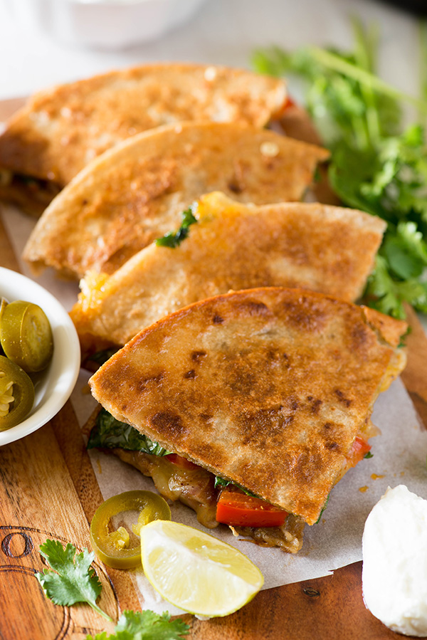 Delicious and healthier Vegetarian Quesadilla recipe made with using multigrain tortillas. Bursting with Mexican flavors, lots of veggies and beans this healthy quesadilla is a perfect recipe to enjoy for any meal.