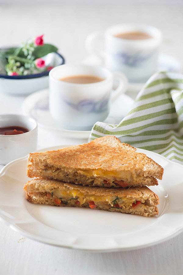 Crispy, buttery hot Capsicum Masala cheese grilled sandwich on a rainy day or a wintery evening, is almost perfect sort of evening snack idea for me or dinner if I just skip the chai, and replace that with hot and steaming bowl of homemade tomato soup.