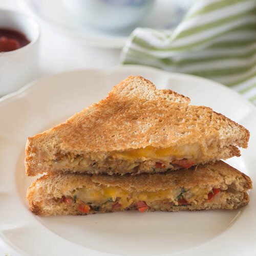 Crispy, buttery hot Capsicum Masala cheese grilled sandwich on a rainy day or a wintery evening, is almost perfect sort of evening snack idea for me or dinner if I just skip the chai, and replace that with hot and steaming bowl of homemade tomato soup.