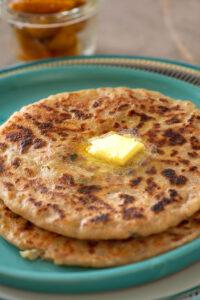Mashed potatoes stuffed flatbread topped with butter