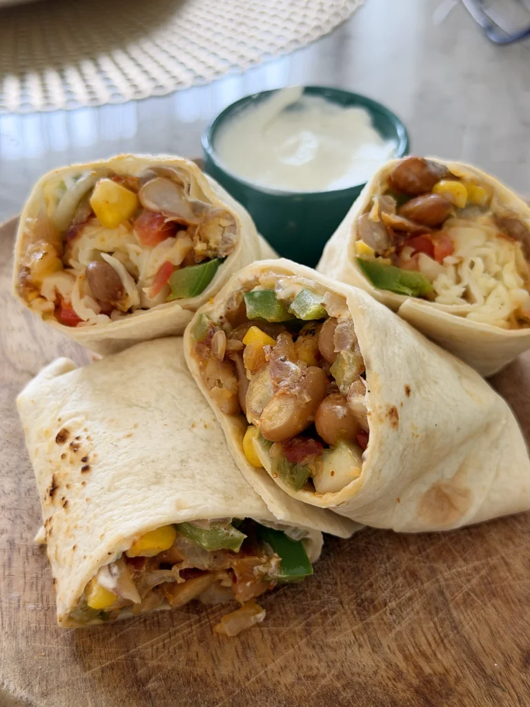 Easy vegetarian bean burrito filled with smoky pinto beans, corn, green bell pepper, fresh vegetables, jalapeƱos, and cheese